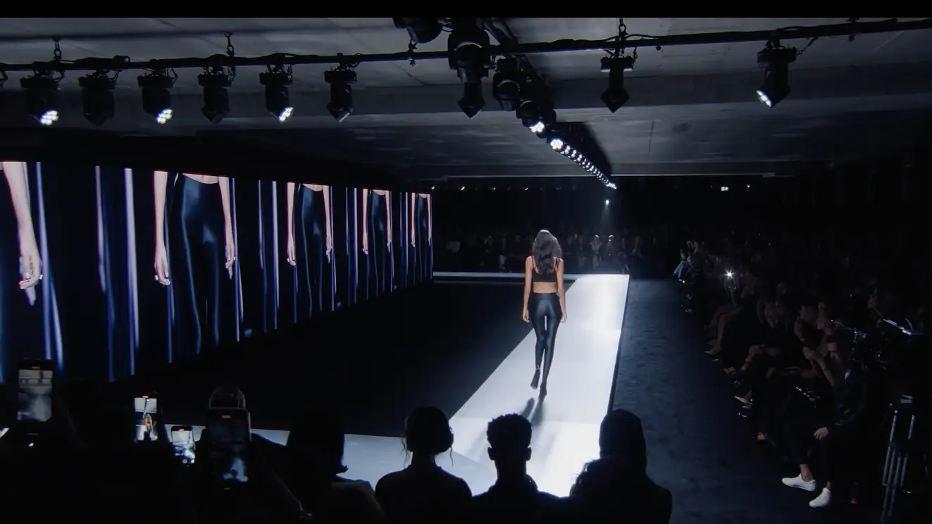 Model on the runway, broadcast playing on screen