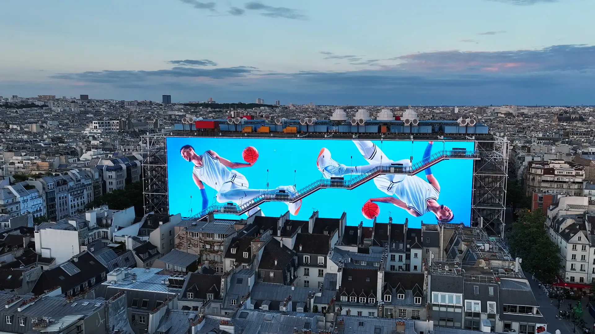 Giant screen displaying a colorful, graphic video of basketball players wearing NIKE sportswear