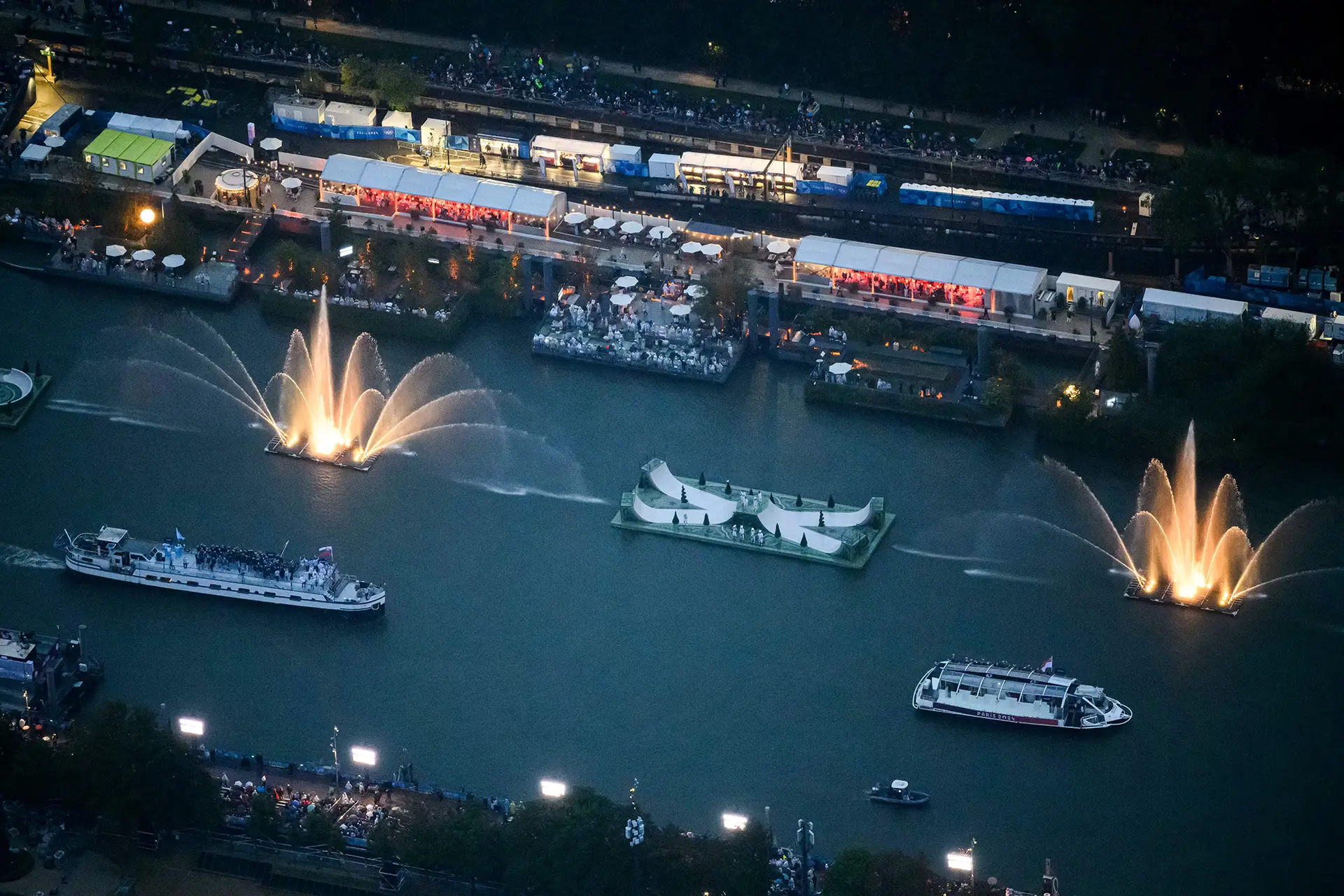 Photo of the seine, filled with boats and water animation, with the audience watching from the shore