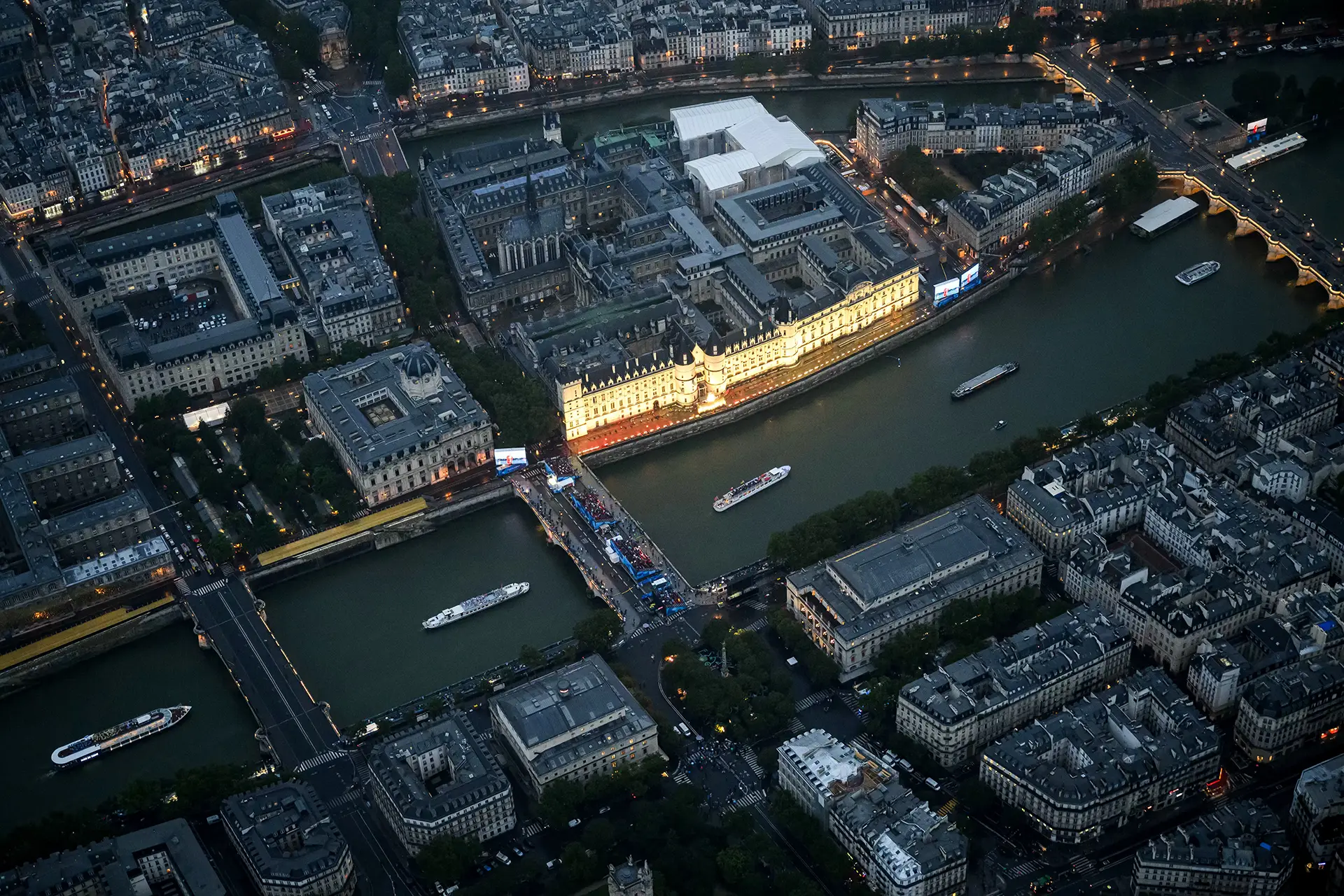 Drone view of the boat parade on the seine while it passes the Conciergerie Palace
