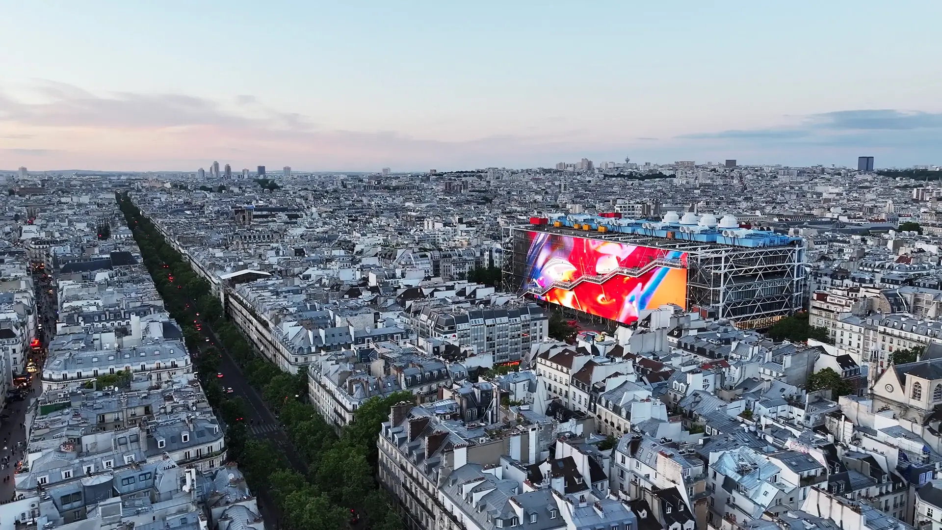 Wide shot showing the scale of the giant screen compared to the size of Paris