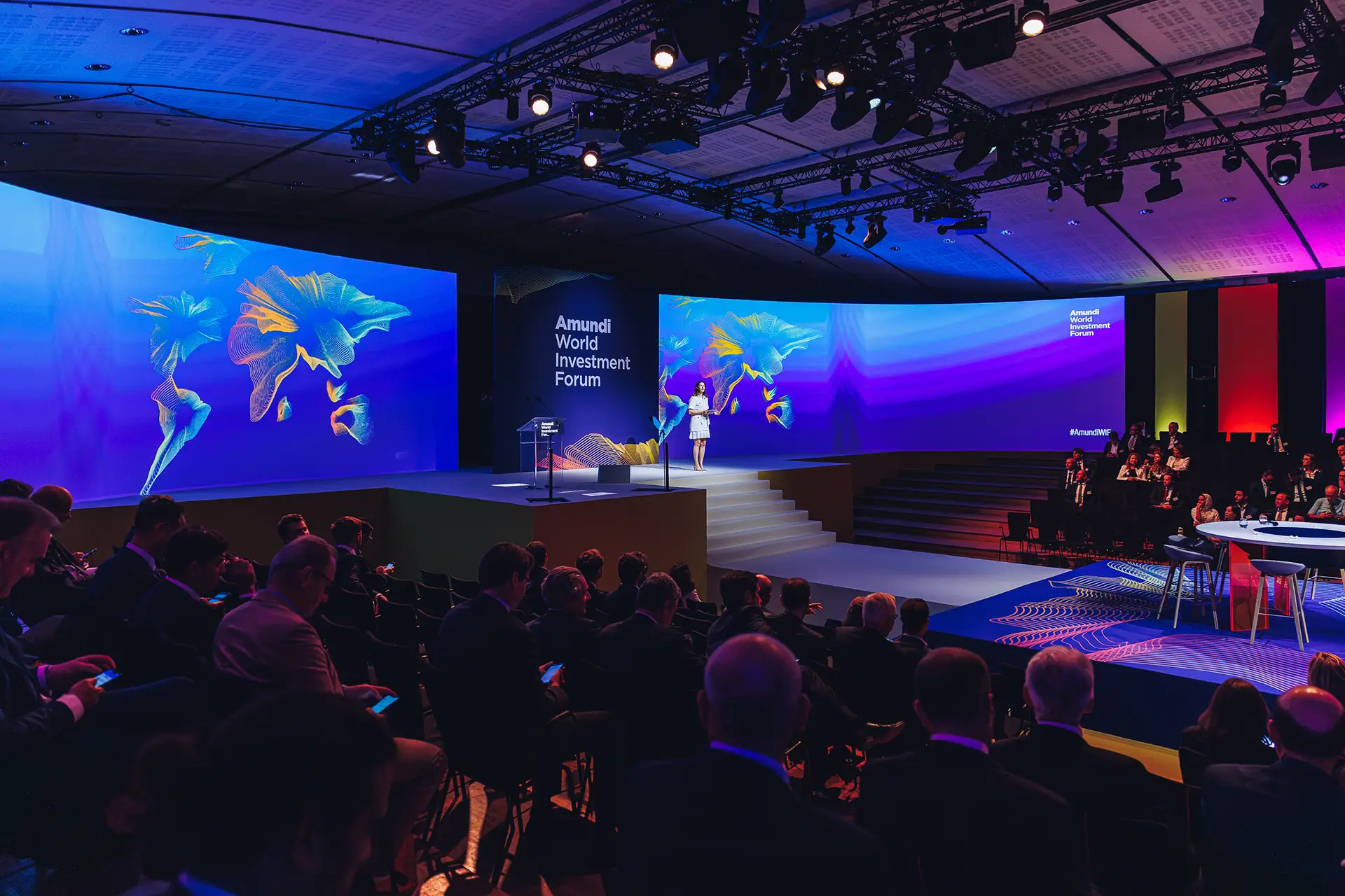 Master of Ceremony addressing the audience, on the main stage with blue lightning variation