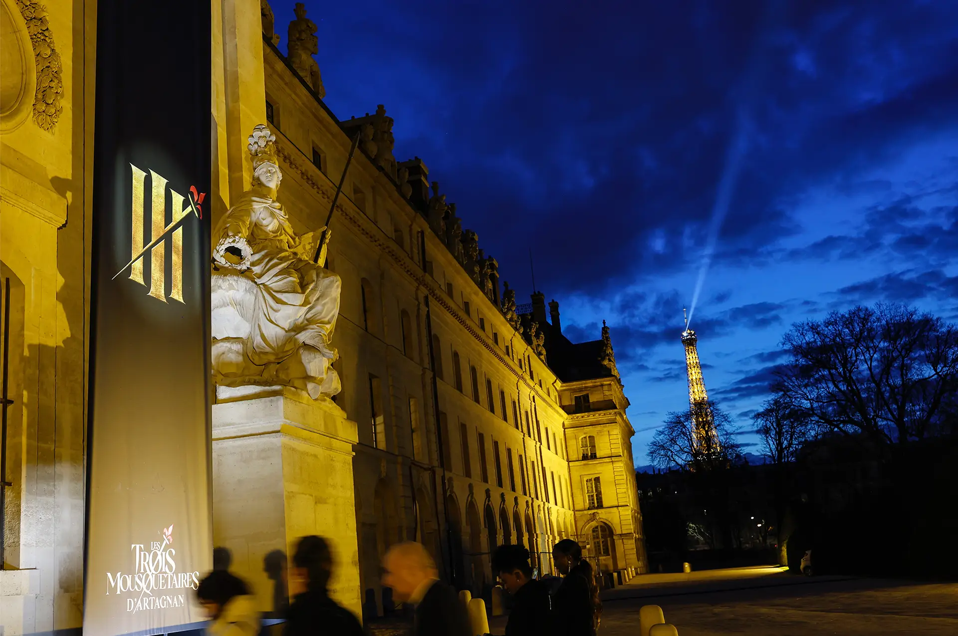 Attendees enter the venue, the Eiffel Tower in the background