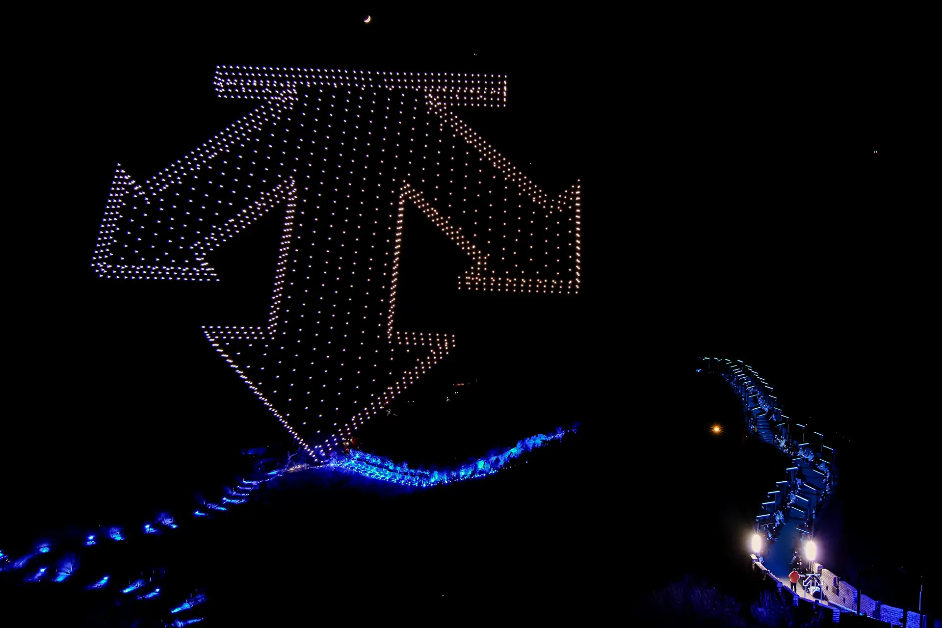 Drone show creating the logo of the brand, DESCENTE runway visible underneath - Great Wall