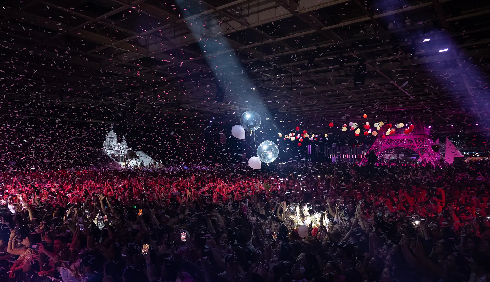 Party photo of the crowd, lights and baloons