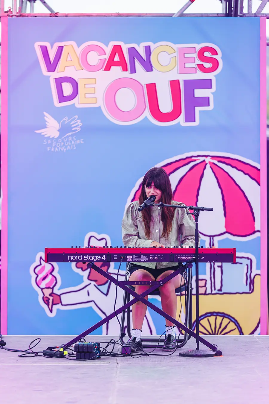 Marguerite singing and playing the piano on stage